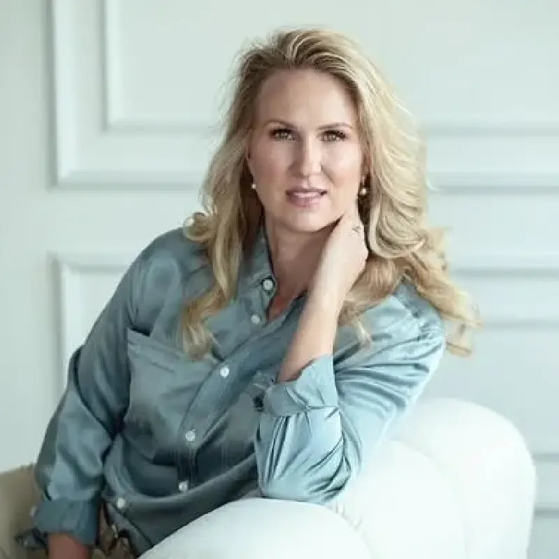 A woman sitting on top of a white couch.